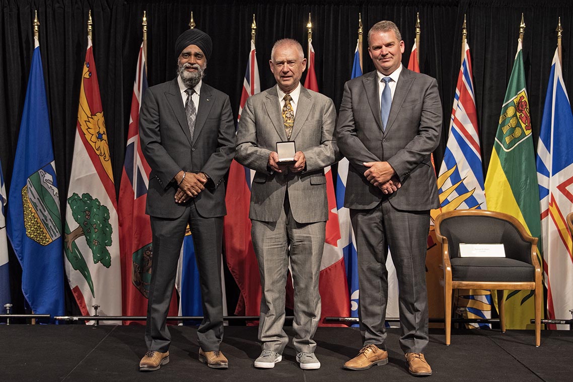 The Honourable Harjit S. Sajjan, President of the King’s Privy Council for Canada and Minister of  Emergency Preparedness (far left) and Minister responsible for the Pacific  Economic Development Agency of Canada, and the Honourable Bloyce Thompson, Deputy  Premier, Minister of Justice and Public Safety and Attorney General for Prince  Edward Island (far right) are pictured with the 2022 award recipient of the  Emergency Management Exemplary Service Award for the Search and Rescue  category.
