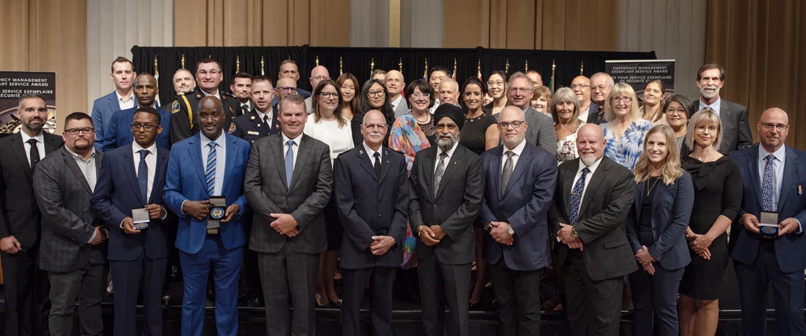 The Honourable Harjit S. Sajjan, President of the King’s Privy Council for Canada and Minister of  Emergency Preparedness (far left) and Minister responsible for the Pacific  Economic Development Agency of Canada, and the Honourable Bloyce Thompson, Deputy  Premier, Minister of Justice and Public Safety and Attorney General for Prince  Edward Island (far right) are pictured with the 2022 award recipient of the  Emergency Management Exemplary Service Award for the Outstanding Contribution  to Emergency Management category.