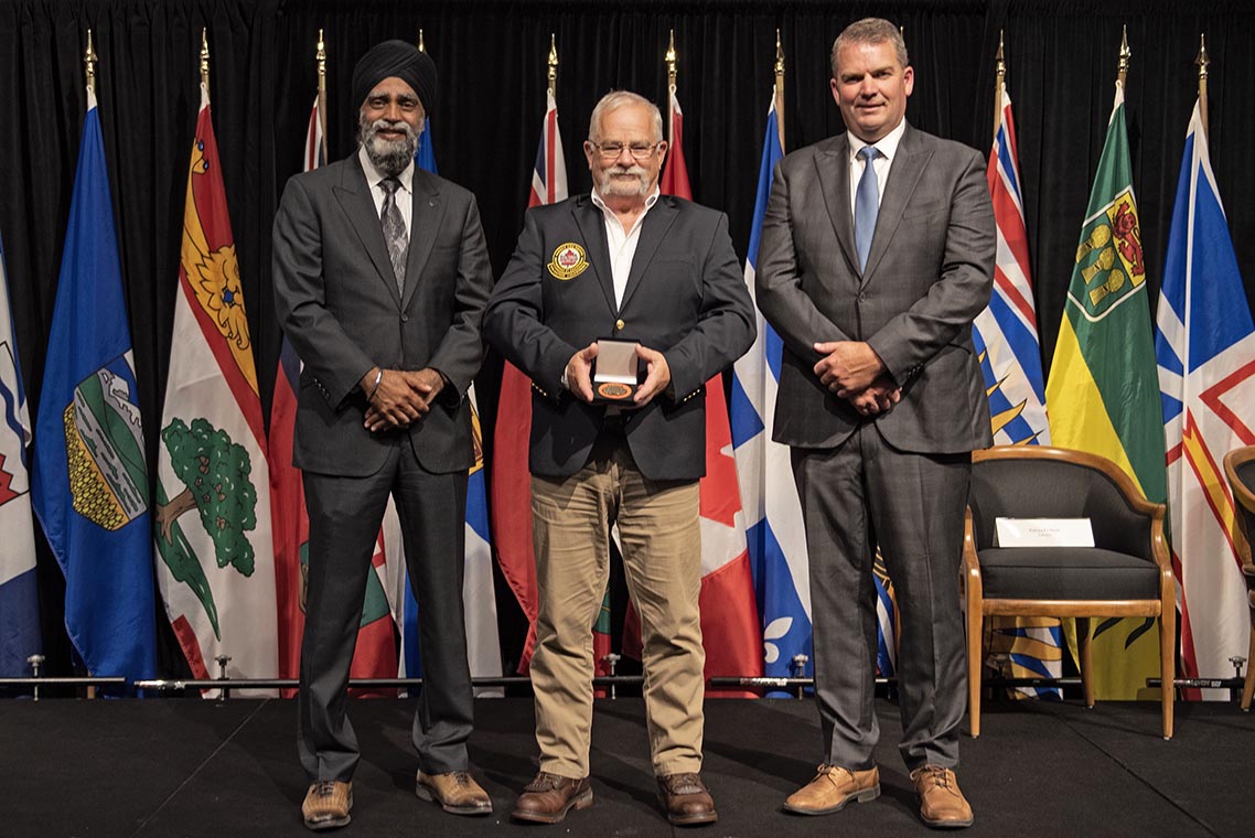 The Honourable Harjit S. Sajjan, President of the King’s Privy Council for Canada and Minister of Emergency  Preparedness (far left) and Minister responsible for the Pacific Economic  Development Agency of Canada, and the Honourable Bloyce Thompson, Deputy  Premier, Minister of Justice and Public Safety and Attorney General for Prince  Edward Island (far right) are pictured with the 2022 award recipient of the  Emergency Management Exemplary Service Award for the Search and Rescue Volunteers  category.