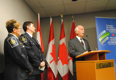 The Honourable Vic Toews, Minister of Public Safety joined by CBSA officials Yvonne Brémault, Southern Manitoba District Director, and Blair Downey, Port Emerson Chief